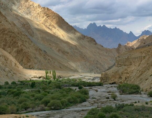 Scenic landscape of Markha Valley Trail, with mountains, river, and blue sky