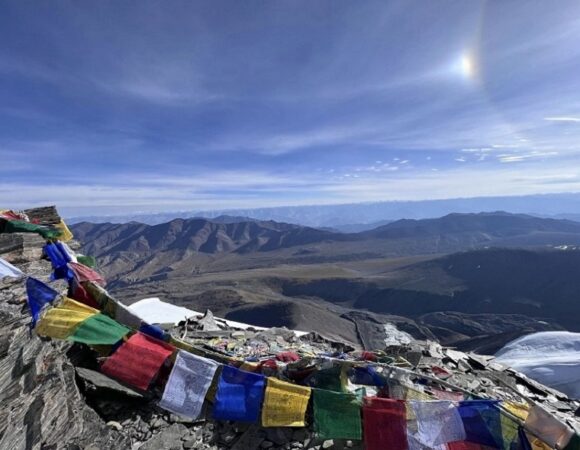 Buddhist Flag waving proudly at the Summit of Kangyatse 2 with a breathtaking view of Kangyatse 1 Peak.