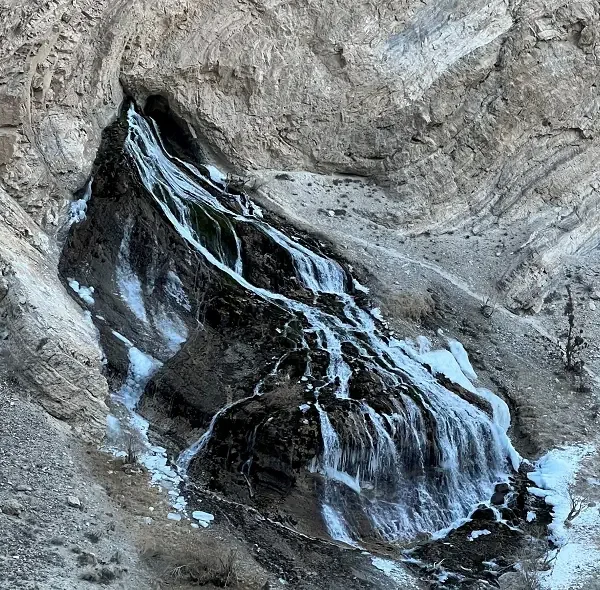 Tsomo Waterfall partially frozen along the Chadar Trek route in Ladakh’s rugged terrain.