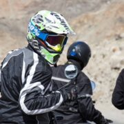 Close-up of a biker in protective gear during a Ladakh bike trip, surrounded by rugged Himalayan terrain.